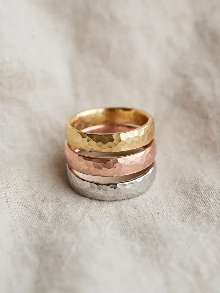mixed metal wedding rings stack with hammered textured organic bands in yellow, rose and white gold