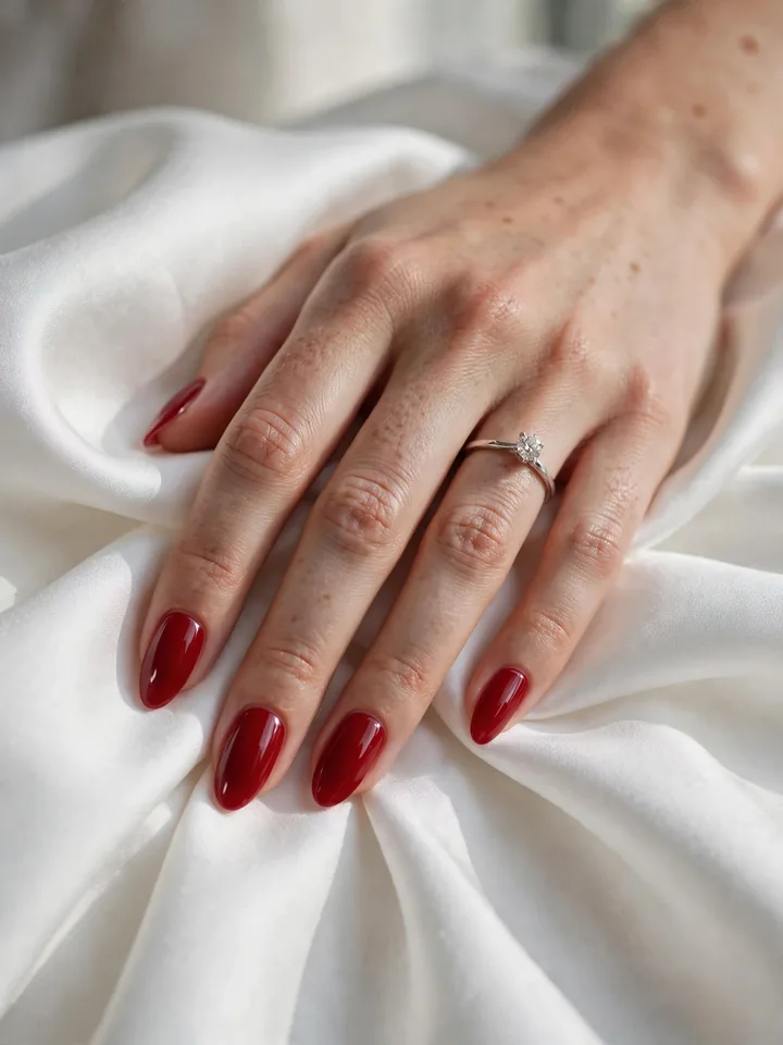 Red wedding nails idea: classic cherry red polish on elegant almond-shaped nails