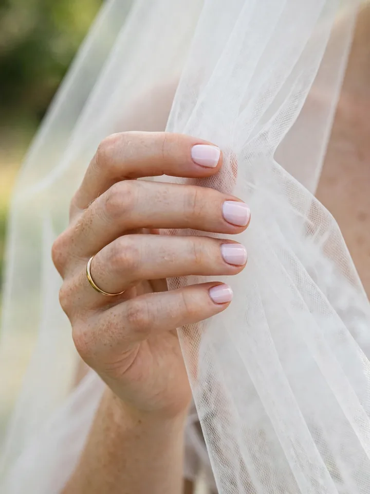 Short square wedding nails in pale pink polish, practical bridal manicure