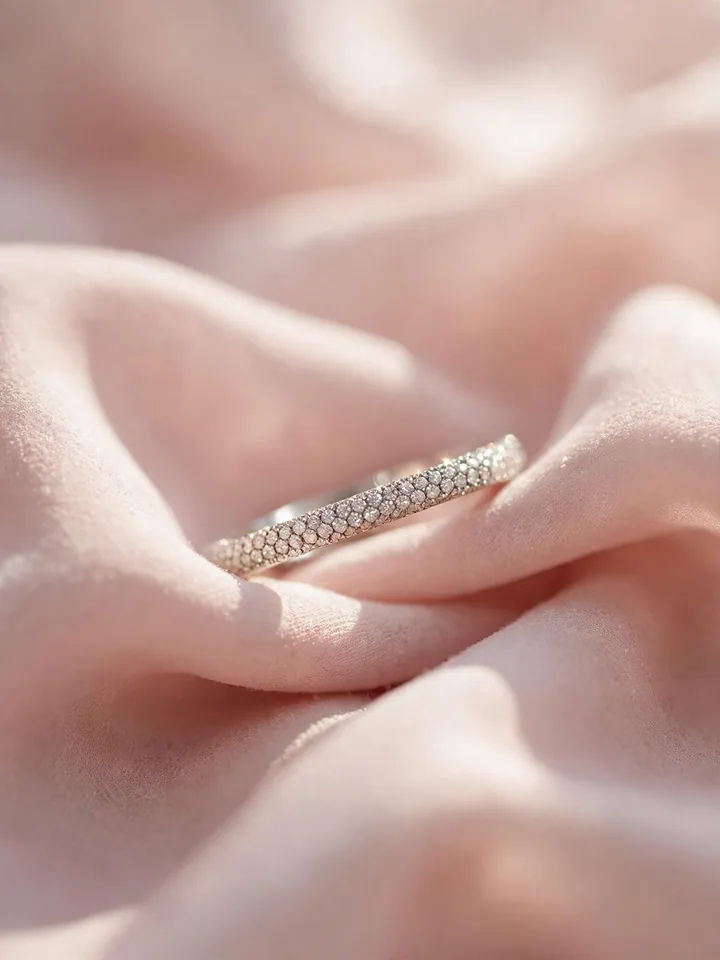 Timeless wedding rings: a delicate pavé diamond wedding band sparkling on blush fabric