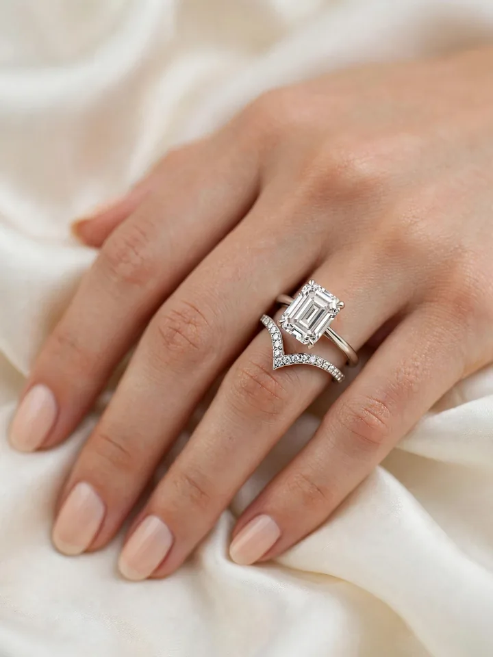 Wedding bands for emerald cut rings — open-gap wedding band with negative space beside an emerald-cut ring